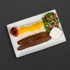 Beef koobideh plate with rice, tomato, and salad.