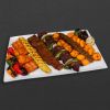 Skewer plate with salmon, chicken koobideh, barg, shish kebab, chicken kebab, beef koobideh, shrimp, and peppers.
